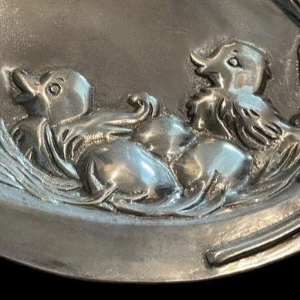 Silver platter with embossed design of ducks and a nest