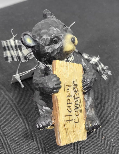 Small figurine of a bear with a sign on a textured surface
