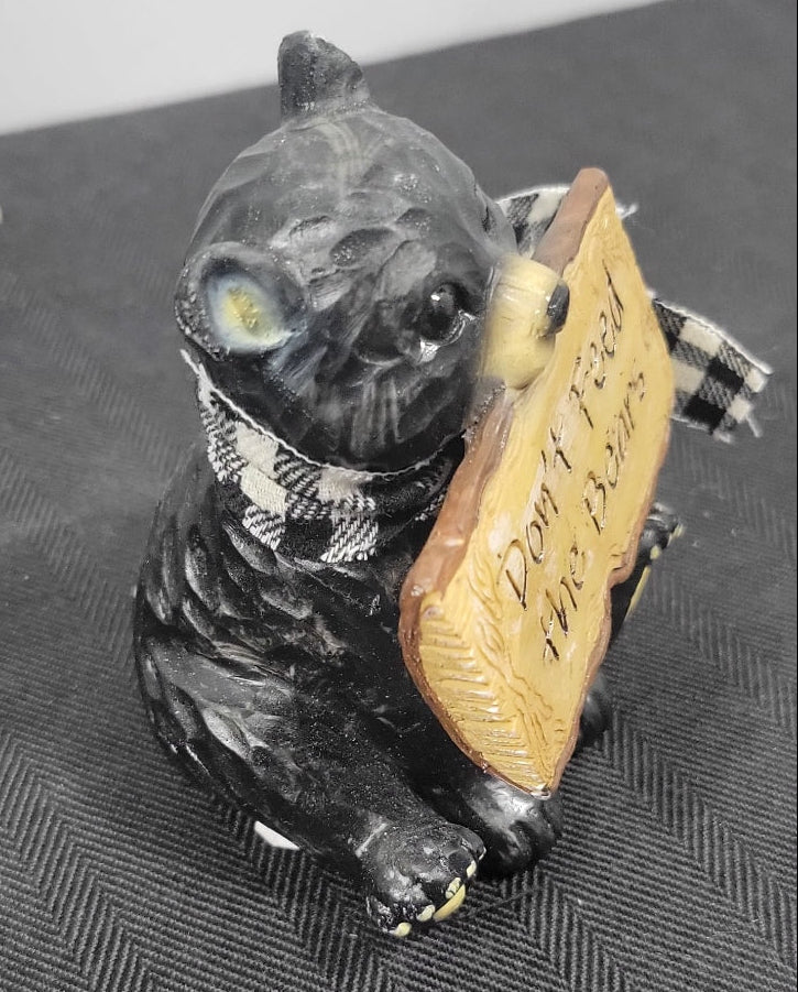 Small black bear with a sign on a textured surface